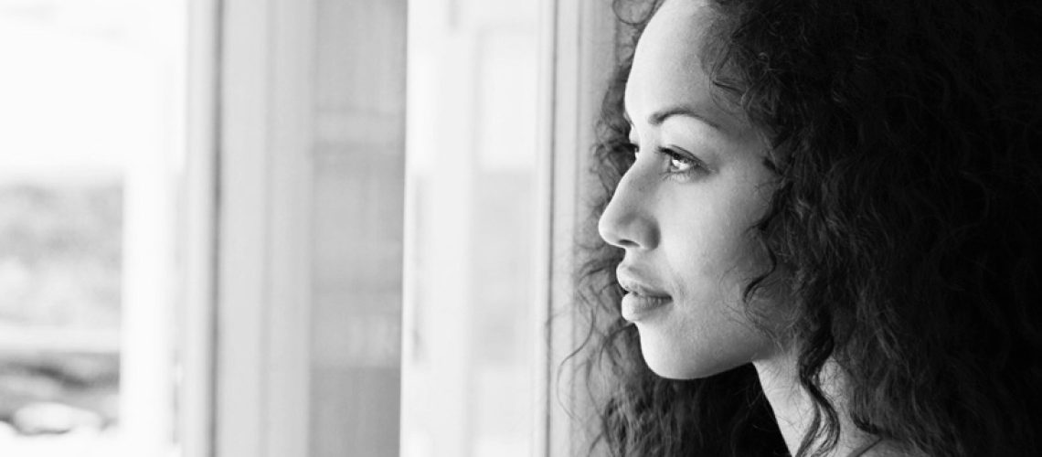 Woman daydreaming at window